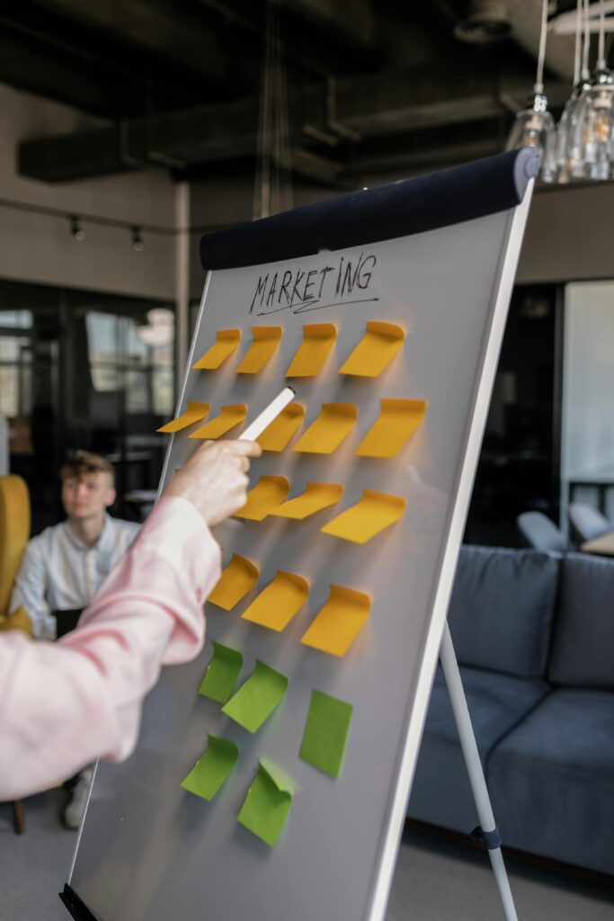 Business professionals brainstorming marketing strategies on a whiteboard with sticky notes.